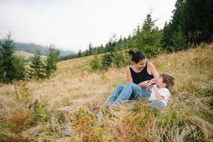 ung mamma med bebis pojke reser. mor på vandring äventyr med barn, familj resa i berg. nationell parkera. vandra med barn. aktiva sommar högtider. foto