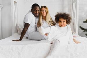 Lycklig interracial par med deras liten dotter på Hem foto