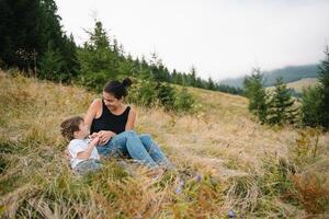 ung mamma med bebis pojke reser. mor på vandring äventyr med barn, familj resa i berg. nationell parkera. vandra med barn. aktiva sommar högtider. foto