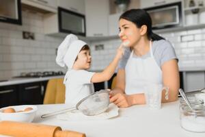 Lycklig familj. mor undervisning henne son på vilket sätt till matlagning kaka meny i morgon. friska livsstil begrepp.. bakning jul kaka och laga mat begrepp foto