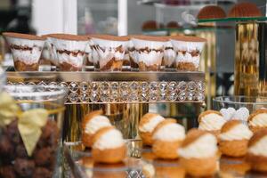 utsökt sötsaker på godis buffé. tabell med sötsaker, buffé med cupcakes, makroner, godis, efterrätt foto