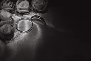 skön bröllop guld ringar på mörk bakgrund foto