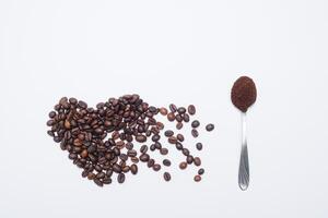 hjärta formad kaffe bönor med grunder och sked foto