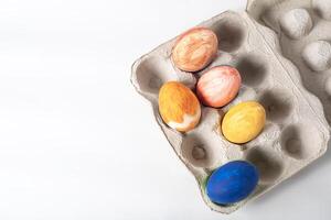 färgrik målad påsk ägg på en kartong låda på en vit bakgrund foto
