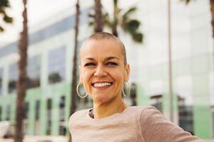 Lycklig kvinna leende Sammanträde i en parkera foto