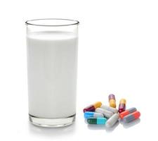 piller och glas mjölk isolerad på vit bakgrund foto