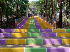 färgrik regnbåge trappa i blommig trädgård i salatiga stad, central java, indonesien foto