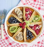 klassisk amerikan pannkakor med frukt på en ljus bakgrund. topp se, närbild. foto