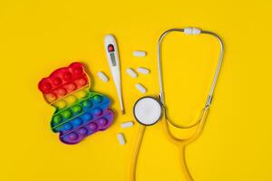 pediatrik begrepp. stetoskop och leksak på en gul bakgrund. barns medicin. foto