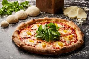 öken- bläs pizza isolerat på mörk bakgrund med rå mat topp se av italiensk snabbmat aptitretare foto