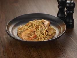 tom jams skaldjur pasta en maträtt isolerat på mörk trä- tabell sida se singapore mat foto