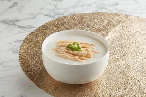 strimlad ångad kyckling congee eras i en skål sida se på grå marmor bakgrund traditionell vietnamese mat foto