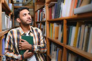Lycklig smart indisk eller arab kille, blandad lopp manlig, universitet studerande, i de bibliotek foto