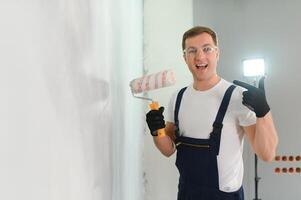 arbetstagare målare målarfärger en vägg. professionell byggare gör reparationer. foto