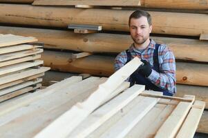 byggare innehar trä- plankor. begrepp - försäljning av virke. byggare är med tanke på trä plankor. begrepp - trä bearbetning företag. trä timmer stack av trä- plankor. foto
