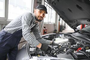 professionell mekaniker är arbetssätt på en bil i en bil service. foto