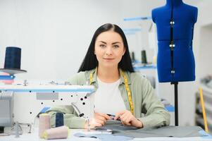 ung kvinna arbetssätt som sömmerska i Kläder fabrik. foto