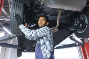 service, reparera och yrke begrepp - indisk mekaniker på bil service foto