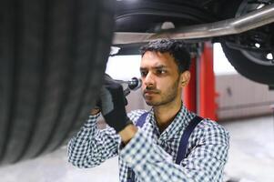stilig indisk bil mekaniker på bil serva foto