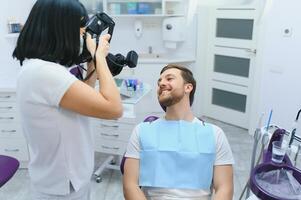 dental vård begrepp. stilig ung kille på de tandläkarens kontor. foto