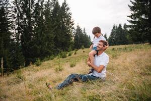 far och barn vandring i naturskön berg. pappa och son njuter de se från de berg topp i karpater bergen foto