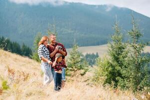 ung familj med barn vilar på en berg foto