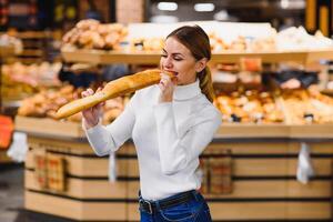 söt fransk kvinna i en randig t-shirt innehav en baguette i de händer foto
