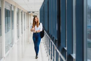 porträtt av en Söt kvinna studerande med böcker och en ryggsäck i de universitet hall foto