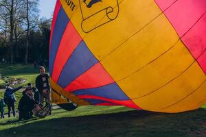 en man blåses upp en ballong på en ballong festival foto