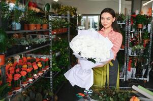 skön ung blomsterhandlare i blomma affär foto