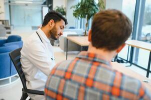 medicin, sjukvård och människor begrepp - indisk läkare ger recept till manlig patient på klinik foto