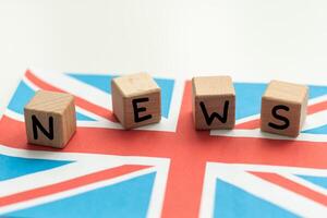 begrepp Nyheter matar - brytning Nyheter, bra storbritannien landets flagga, svarta tavlan och de text brytning Nyheter på trä- bakgrund foto