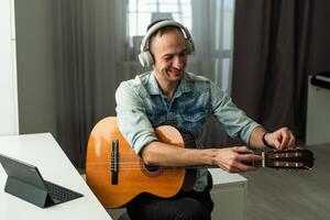 de kille i leva uppkopplad leva uppgifter poddsändningar, spelar gitarr. han kommunicerar med människor, ler, och kör hans egen musik blogg. foto