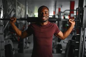 afrikansk amerikan ung man håller på med träna på de Gym foto