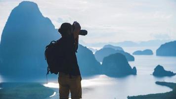 män reser fotografering på berget. turist på sommarlov. landskap vackra berg på havet vid samet nangshe utsiktspunkt. phang nga bay, resor thailand, reseäventyr natur. foto