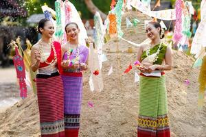 skön thai ung lady gods thai traditionell klänning stå och chattar på lugg av sand i tempel och suddig bakgrund. foto