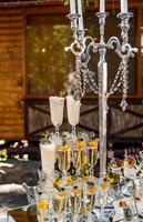 ljusstake och tre vertikal rader av kristall champagne glasögon. rik och modern dekoration. närbild. foto