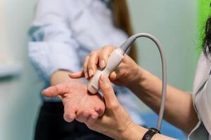 midsection av radiologisk tekniker läser in kvinna patientens hand foto