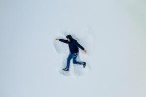 ung pojke är framställning figur i snö. vinter- kallelser. framställning roligt i snö. foto