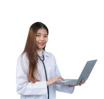en kvinna bär en vit labb täcka är innehav en bärbar dator dator. hon är leende och hon är Lycklig foto