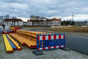 plast orange och blå rör och en bärbar barriär lögn på en konstruktion webbplats. foto