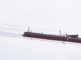 röd kugghjul tåg resor i en snöig landskap, zermatt, schweiz. foto