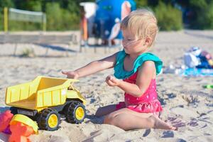 Lycklig litet barn barn spelar på de strand med leksak bil.sommar semester resa begrepp. foto