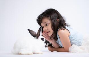 en liten flicka kyssar henne älskad fluffig kanin, de skönhet av vänskap mellan människor och djur foto