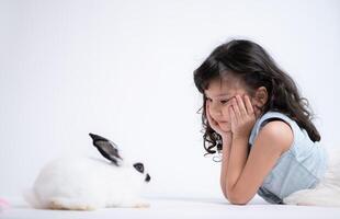 leende liten flicka och med deras älskad kanin, visa upp de skönhet av vänskap mellan människor och djur foto