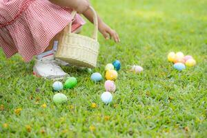 flicka njuter utomhus- aktiviteter i de parkera Inklusive en springa till samla skön påsk ägg. foto