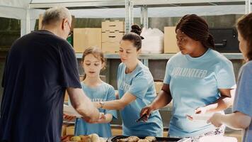 generös volontärer förse mat och donationer för hungrig och hemlös människor. på mat kör, snäll liten flicka och Övrig kvinna välgörenhet arbetare fördelnings fri måltider till de behövande. stativ skott. foto