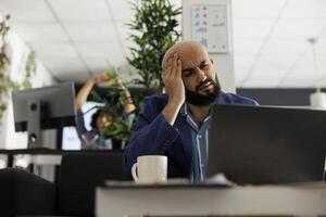 Start upp verkställande lidande från migrän medan håller på med projekt förvaltning på bärbar dator i företag kontor. utmattad entreprenör har huvudvärk medan arbetssätt på digital marknadsföring forskning foto