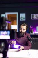 tech specialist i studio filmning teknologi recension av mini led lampor använder sig av professionell kamera. video redaktör som visar filmning Utrustning till prenumeranter, inspelning med specialiserade enheter foto