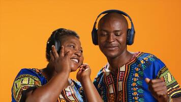 afrikansk amerikan partners dans på headsetet musik i studio, har roligt tillsammans med Häftigt häftig sånger. etnisk par håller på med skraj dansa rör sig och känsla avslappnad med hörlurar. foto